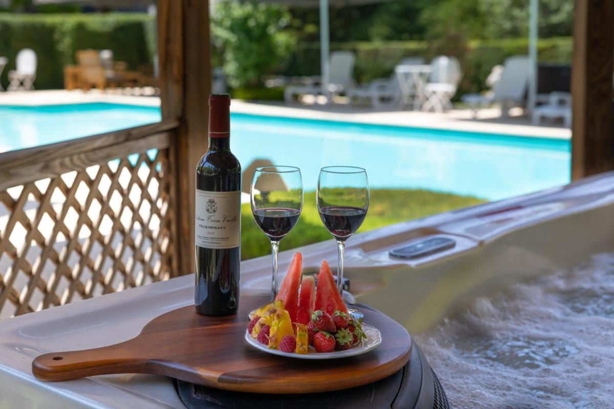 une bouteille de vin et deux verres de vin et des fruits dans l'établissement Le Moulin de Mitou, à Auriac-du-Périgord