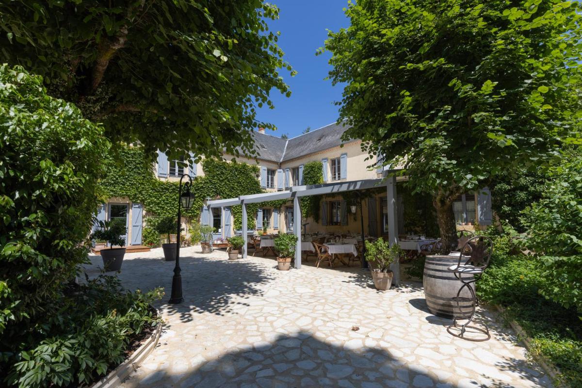 une cour intérieure avec des arbres et un lampadaire dans l'établissement Le Moulin de Mitou, à Auriac-du-Périgord 52 autres photos