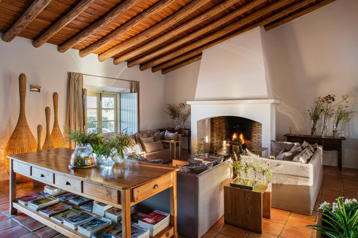 uma sala de estar com lareira e um sofá em Herdade da Malhadinha Nova - Relais & Châteaux em Albernoa mais 67 fotografias