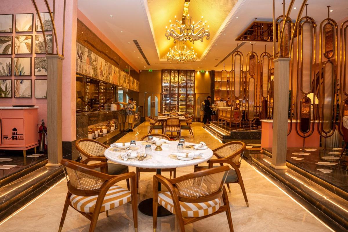 a restaurant with a table and chairs and a chandelier at Crowne Plaza Today Gurugram by IHG in Gurgaon