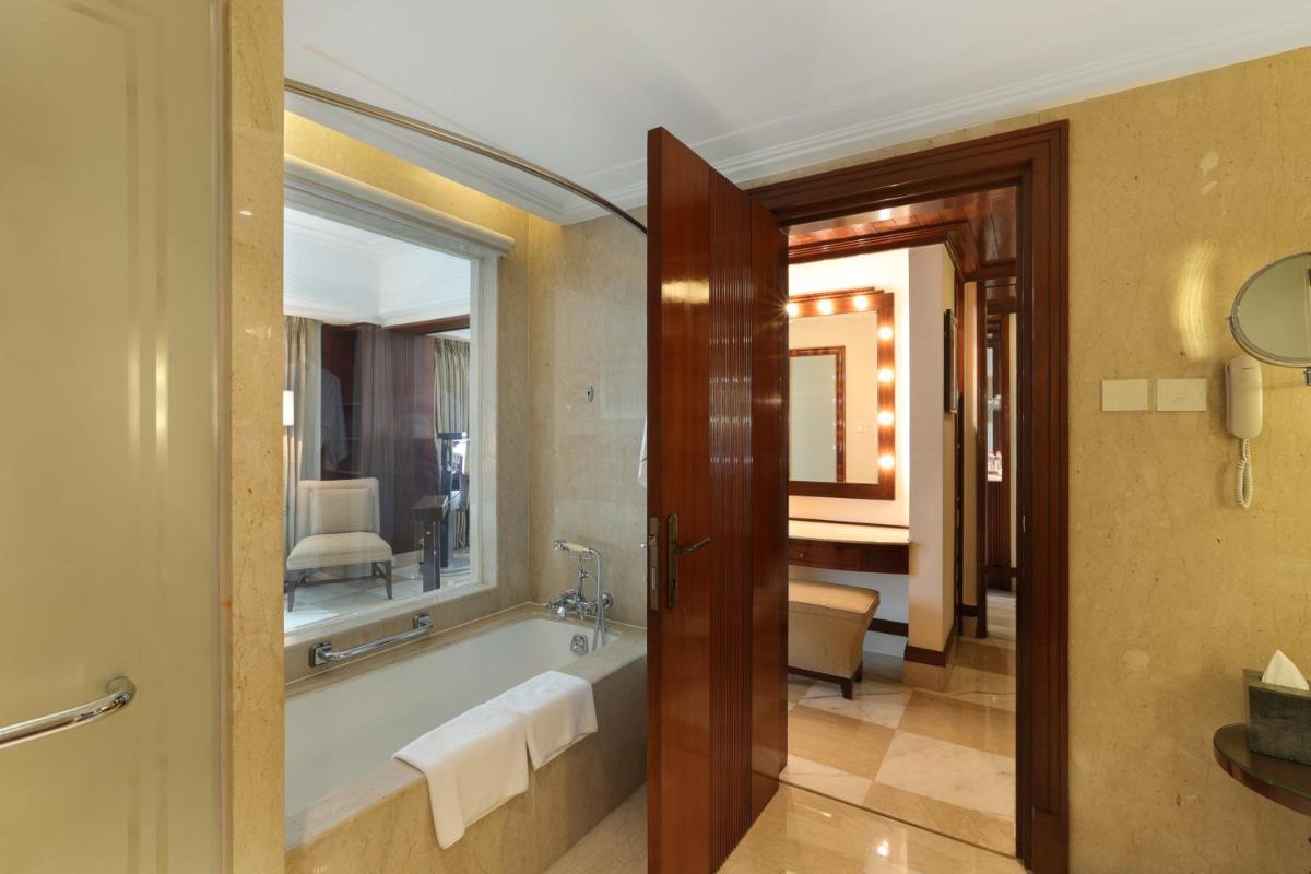 a bathroom with a tub and a large window at The Imperial, New Delhi in New Delhi a bathroom with a tub and a large window at The Imperial, New Delhi in New Delhi