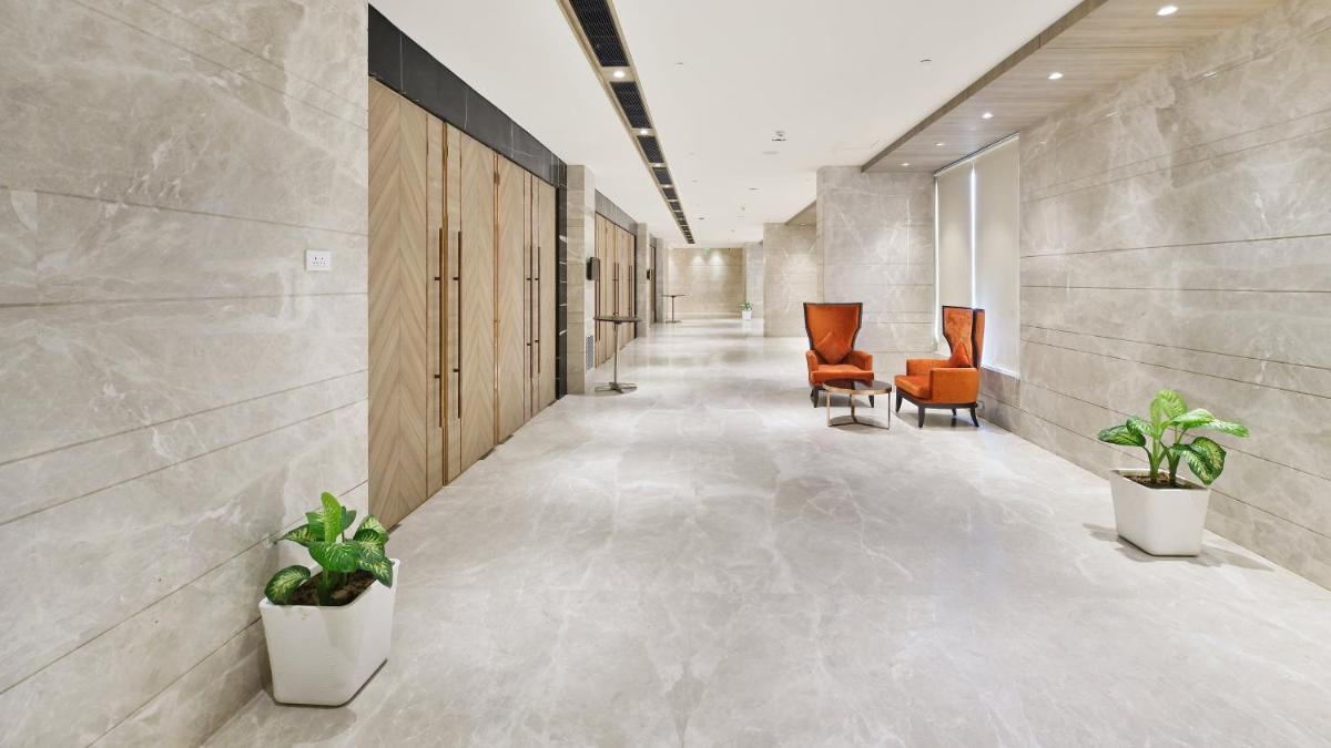 a hallway with chairs and plants in a building at Holiday Inn Gurugram Sector 90 by IHG in Gurgaon