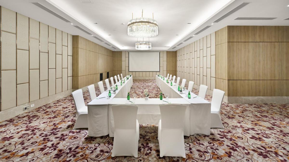 a conference room with a long table and white chairs at Holiday Inn Gurugram Sector 90 by IHG in Gurgaon