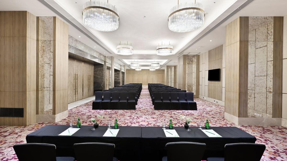 a banquet hall with black tables and chairs and lights at Holiday Inn Gurugram Sector 90 by IHG in Gurgaon
