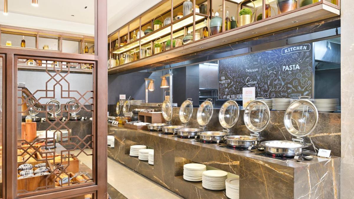 a kitchen with a counter with pots and pans at Holiday Inn Gurugram Sector 90 by IHG in Gurgaon