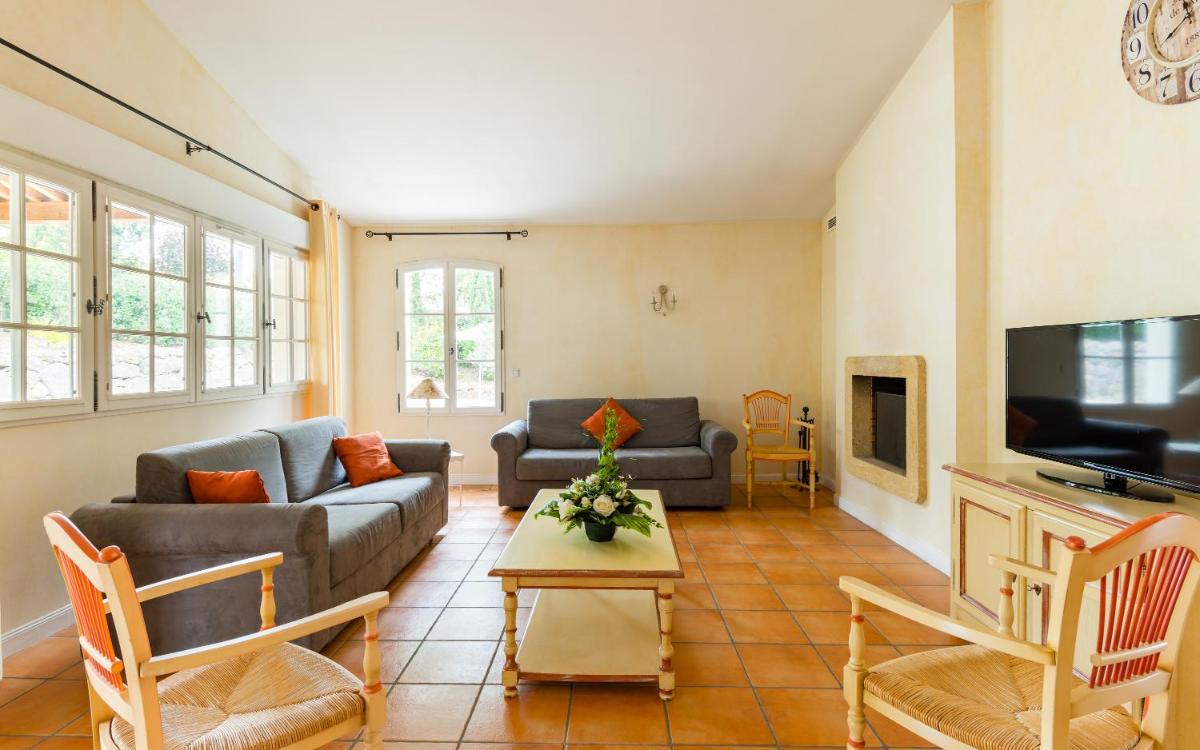 un salon avec un canapé et une télévision dans l'établissement Lagrange Vacances Domaine de Fayence, à Fayence