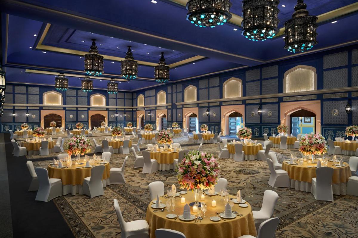 a banquet hall with tables and chairs and chandeliers at Fairmont Jaipur in Jaipur +162 photos