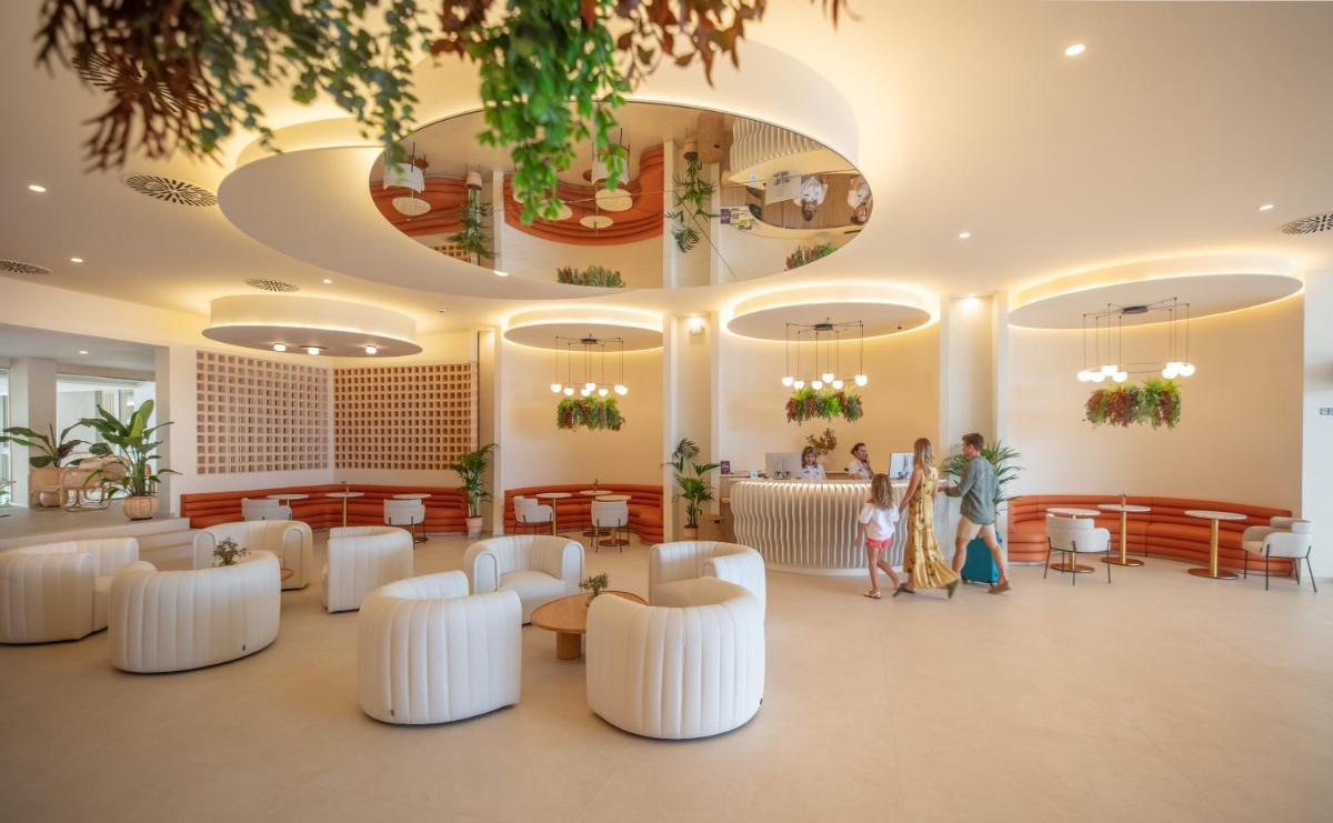 un vestíbulo con sillas y mesas blancas y gente en él en RH Silene Hotel & Spa 4 Sup, en Castellón de la Plana