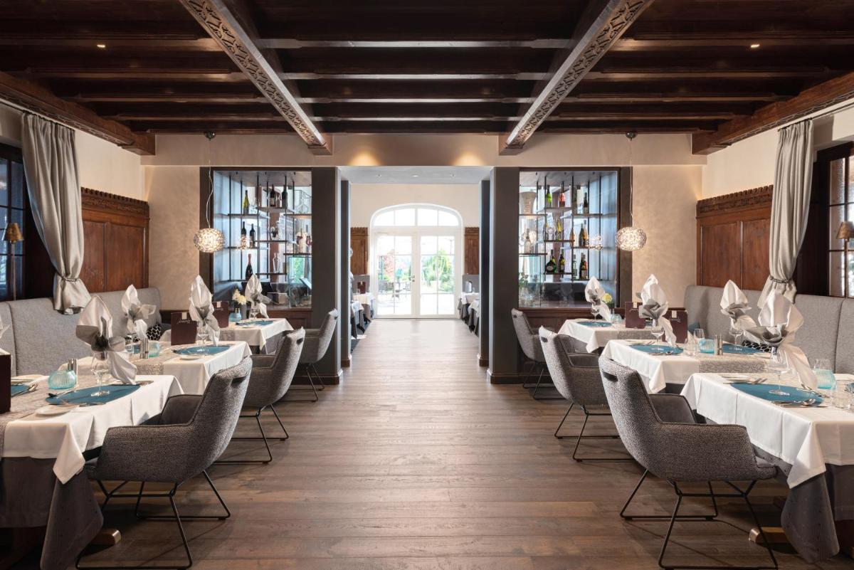 ein Esszimmer mit weißen Tischen und Stühlen in der Unterkunft Wellness- & Sporthotel Jagdhof in Röhrnbach