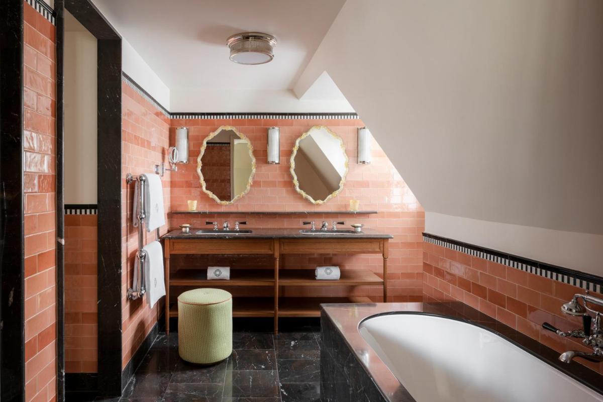 une salle de bain avec un lavabo et deux miroirs dans l'établissement Le Grand Mazarin, à Paris