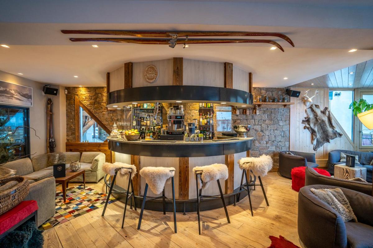 - un salon avec un bar et des tabourets dans l'établissement Hotel 3 Vallées Val Thorens, à Val Thorens