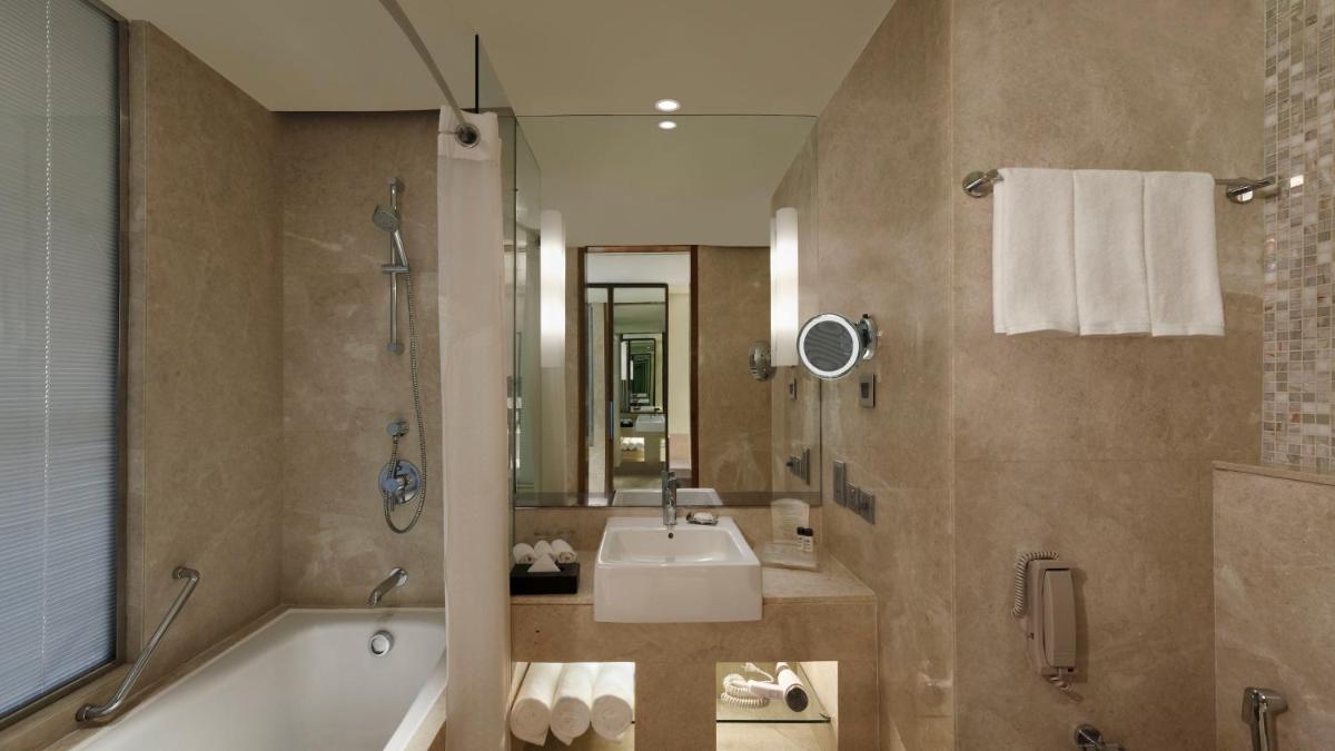 a bathroom with a tub and a sink and a shower at Holiday Inn Jaipur City Centre by IHG in Jaipur a bathroom with a tub and a sink and a shower at Holiday Inn Jaipur City Centre by IHG in Jaipur