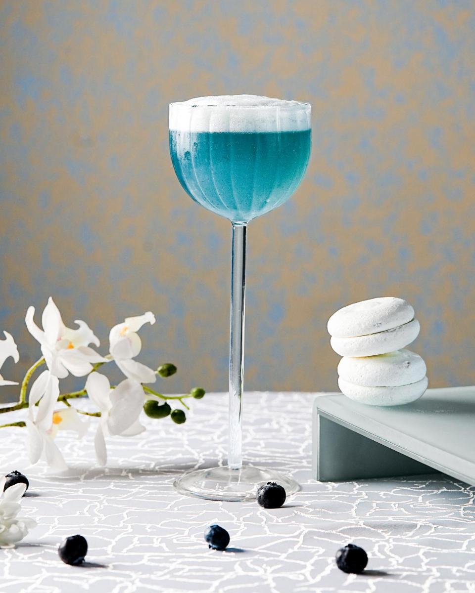 a glass of blue drink on a table with towels at Sheraton Hyderabad Hotel in Hyderabad