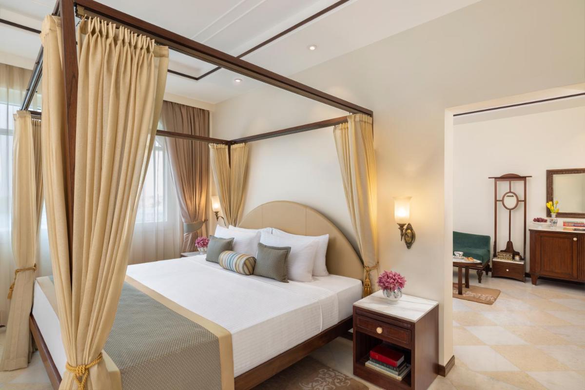 a bedroom with a canopy bed and a room with a table at Tajview, Agra-IHCL SeleQtions in Agra