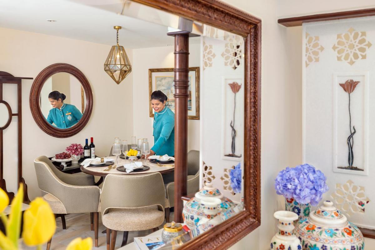 a dining room with a table and a mirror at Tajview, Agra-IHCL SeleQtions in Agra