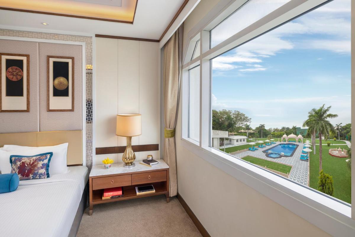 a bedroom with a large window with a view of a pool at Tajview, Agra-IHCL SeleQtions in Agra