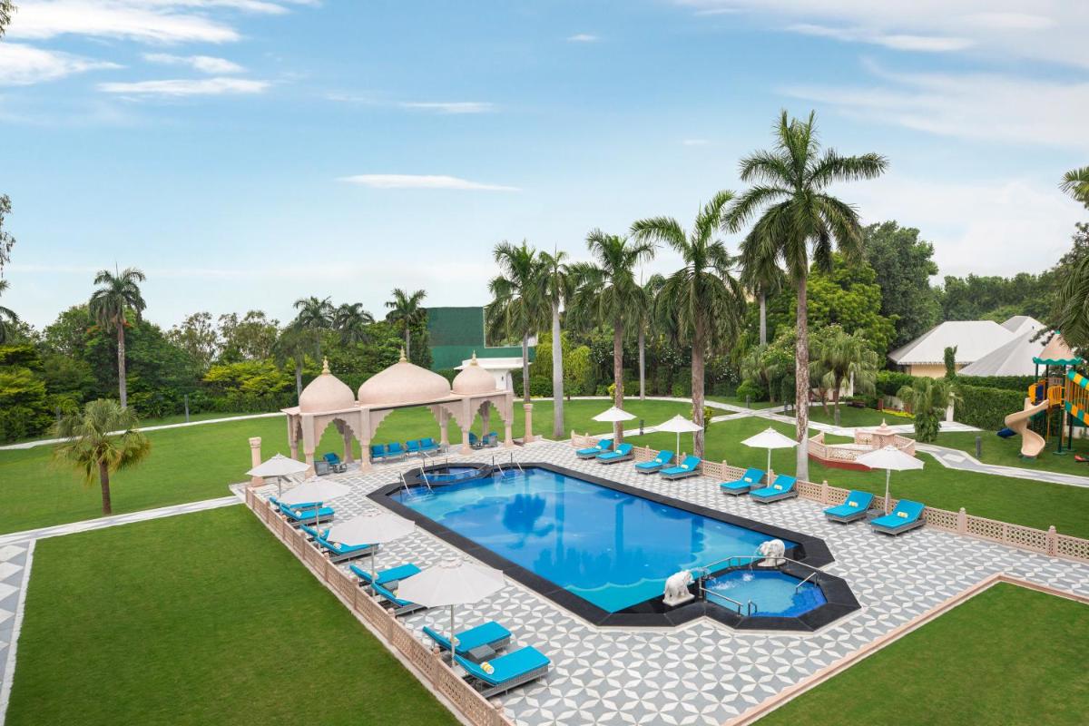 an aerial view of a resort pool with chairs and umbrellas at Tajview, Agra-IHCL SeleQtions in Agra