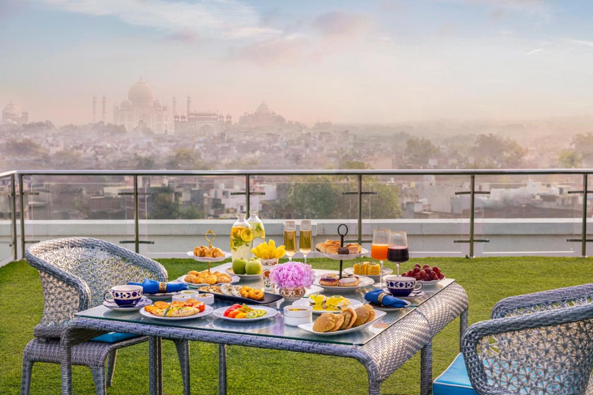 a table with food and drinks on a balcony at Tajview, Agra-IHCL SeleQtions in Agra
