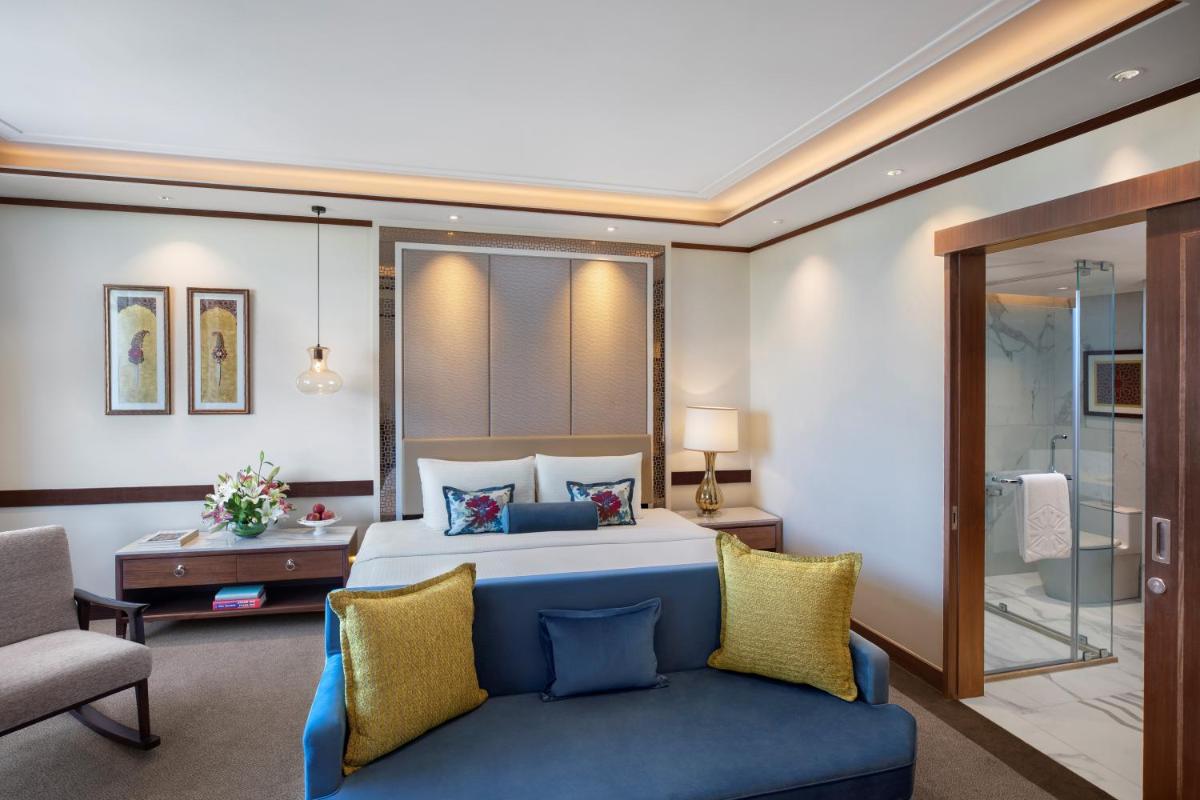 a bedroom with a bed and a couch in a room at Tajview, Agra-IHCL SeleQtions in Agra