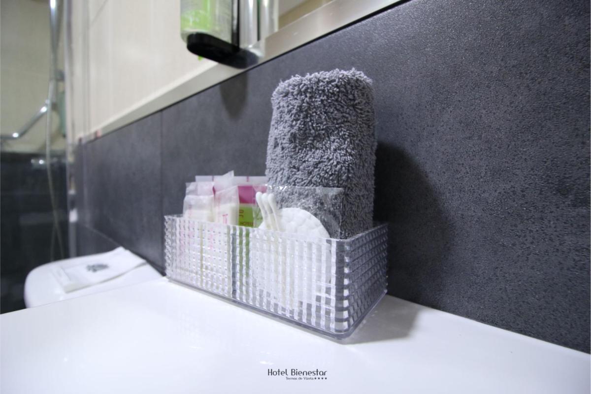 uma cesta de produtos de higiene pessoal num balcão na casa de banho em Hotel Bienestar Termas De Vizela em Vizela