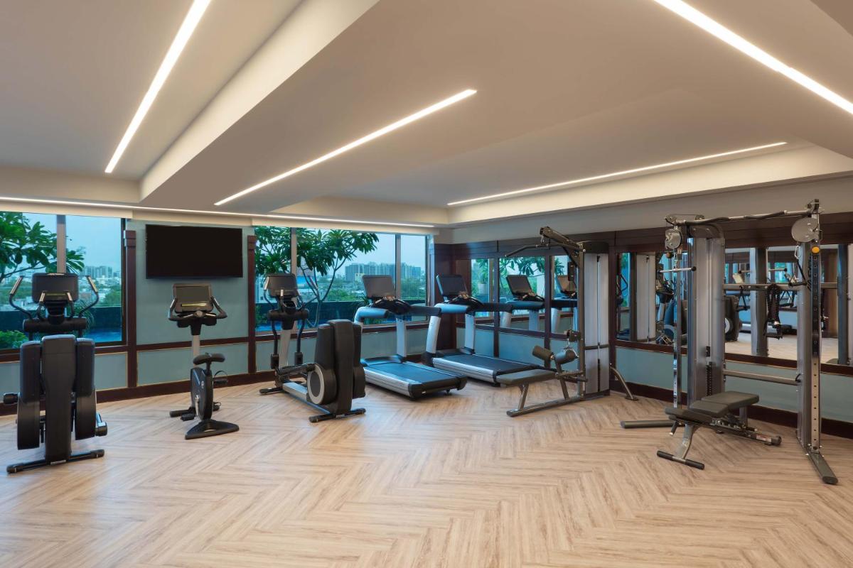a gym with treadmills and elliptical machines at ITC Narmada, a Luxury Collection Hotel, Ahmedabad in Ahmedabad