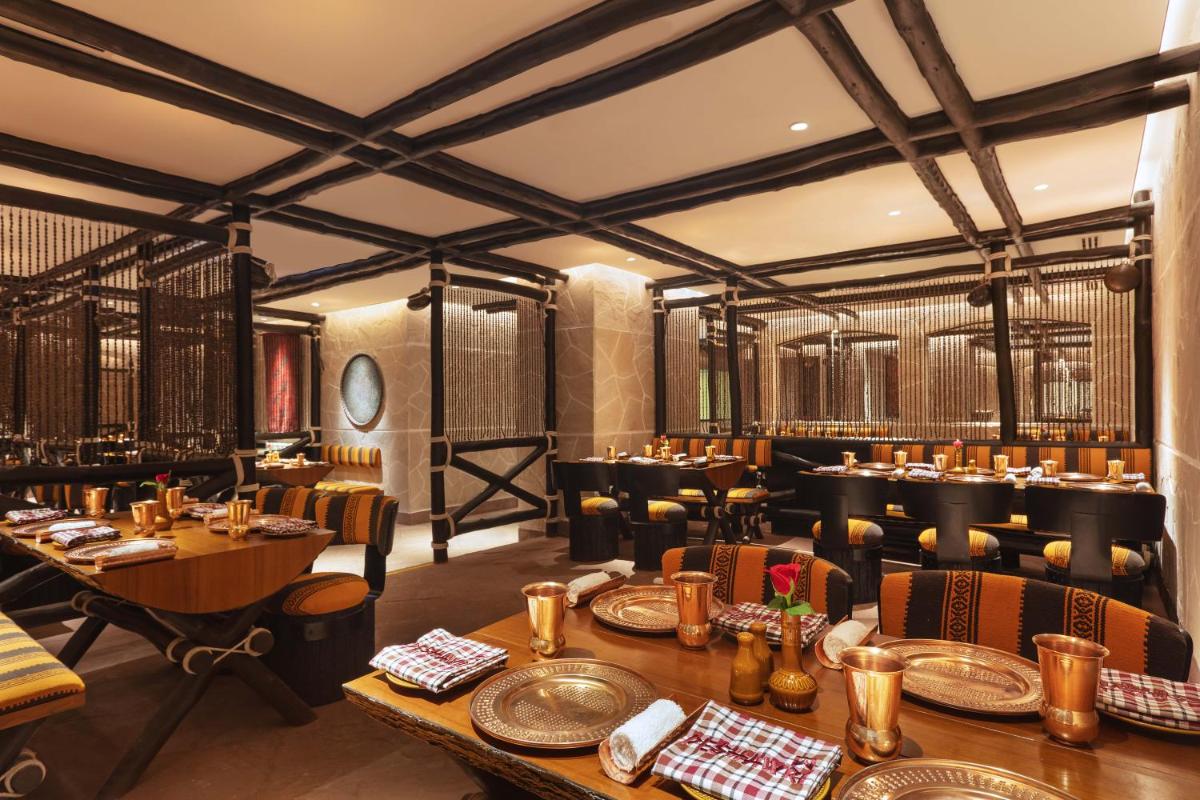 a restaurant with tables and chairs in a room at ITC Narmada, a Luxury Collection Hotel, Ahmedabad in Ahmedabad
