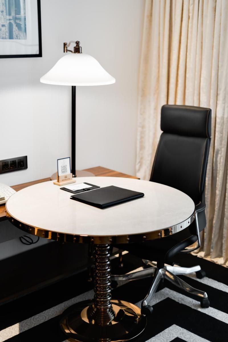 a desk with a lamp and a black chair at ITC Narmada, a Luxury Collection Hotel, Ahmedabad in Ahmedabad