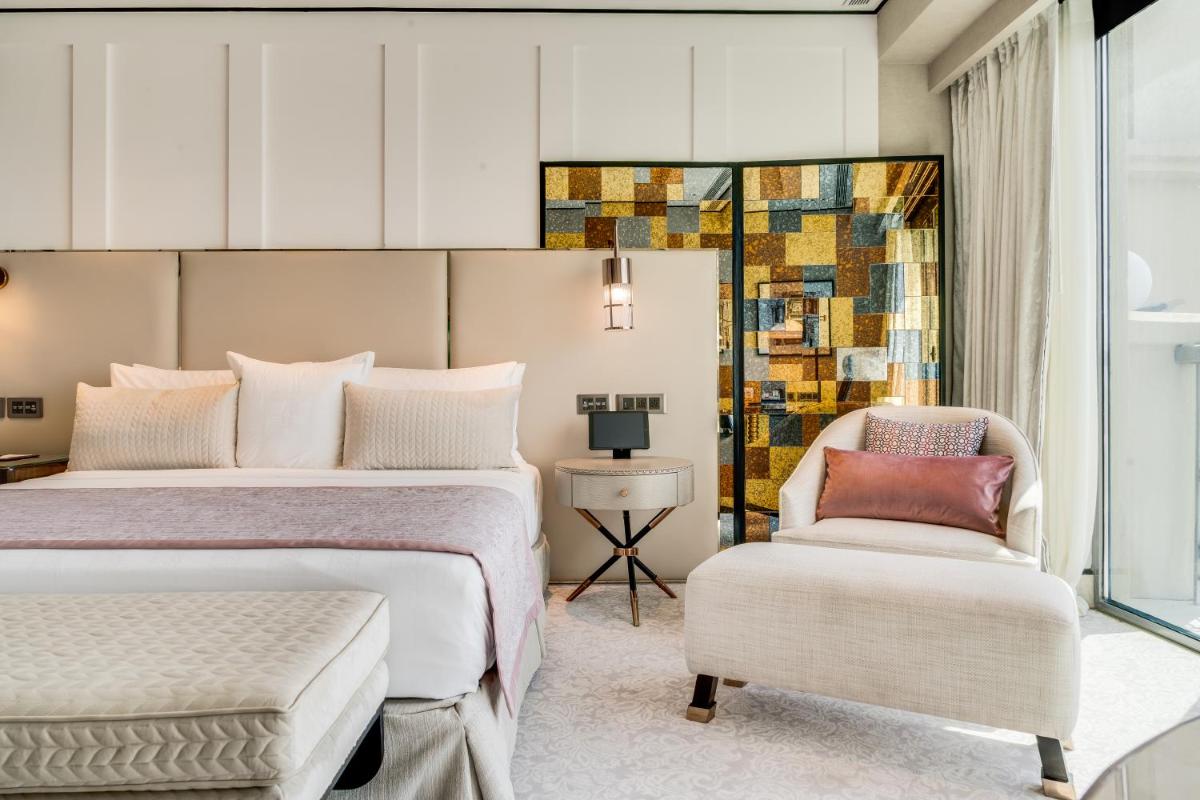 a hotel room with two beds and a chair at ITC Narmada, a Luxury Collection Hotel, Ahmedabad in Ahmedabad