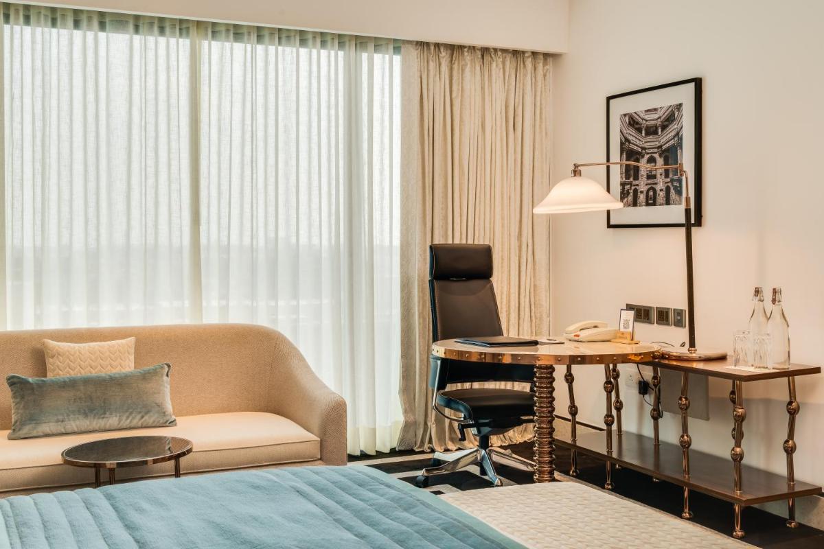 a hotel room with a bed and a desk at ITC Narmada, a Luxury Collection Hotel, Ahmedabad in Ahmedabad
