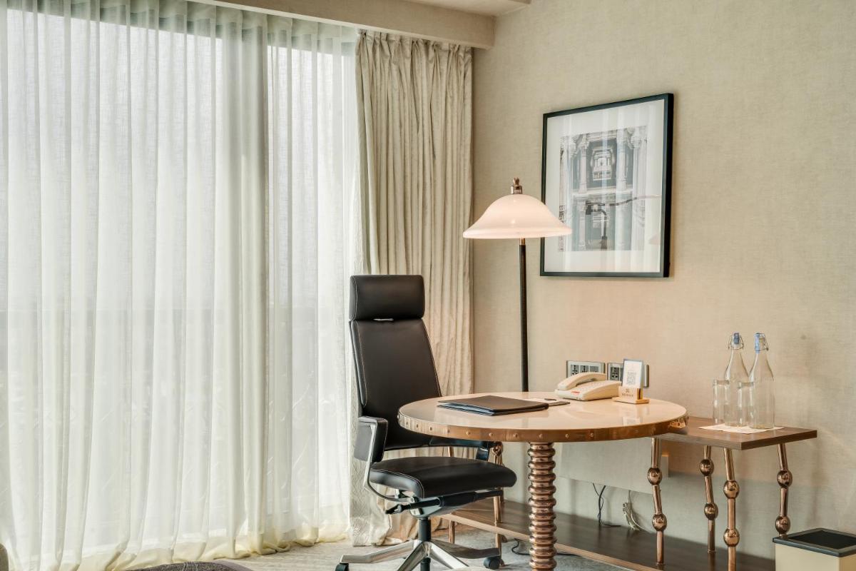 a room with a desk and a chair and a window at ITC Narmada, a Luxury Collection Hotel, Ahmedabad in Ahmedabad