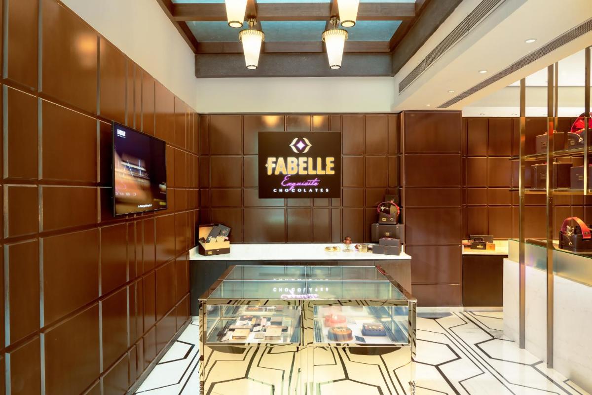 a restaurant with a display case in a room at ITC Narmada, a Luxury Collection Hotel, Ahmedabad in Ahmedabad