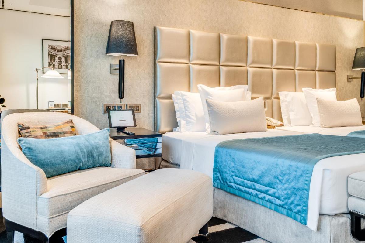 a hotel room with two beds and a chair at ITC Narmada, a Luxury Collection Hotel, Ahmedabad in Ahmedabad