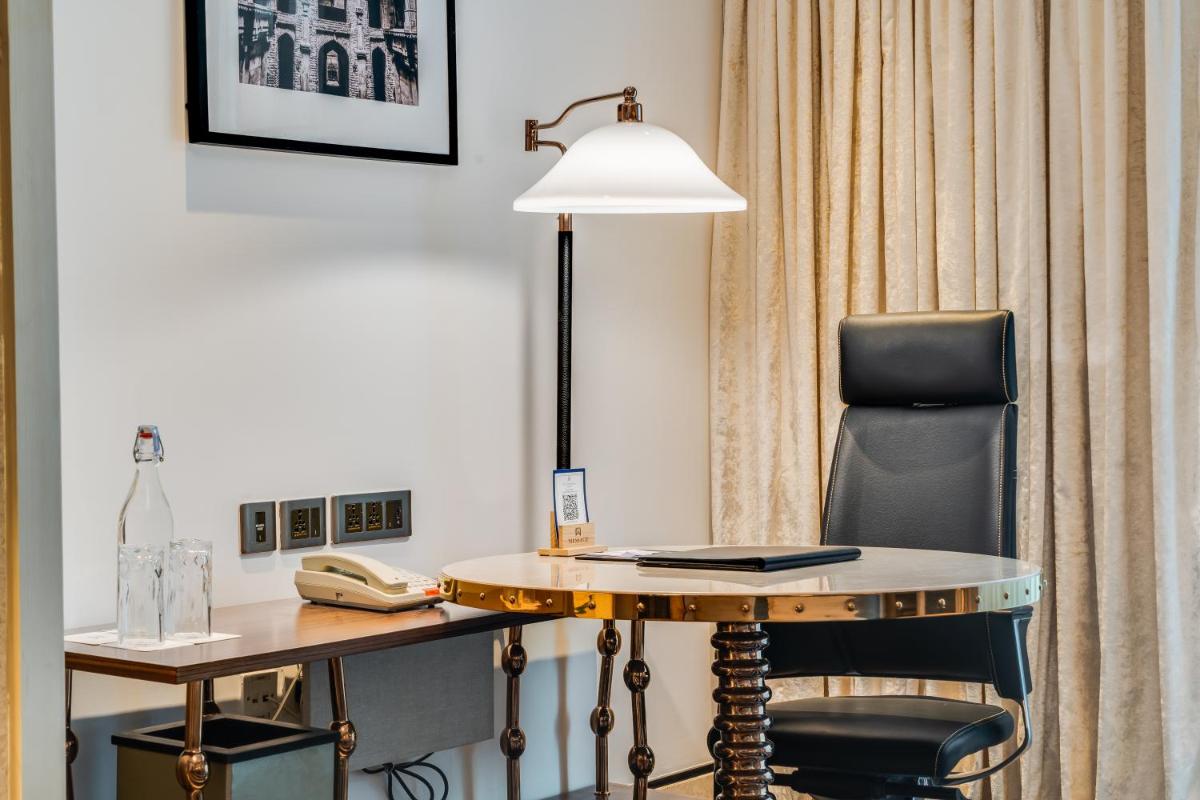 a desk in a hotel room with a lamp and a chair at ITC Narmada, a Luxury Collection Hotel, Ahmedabad in Ahmedabad