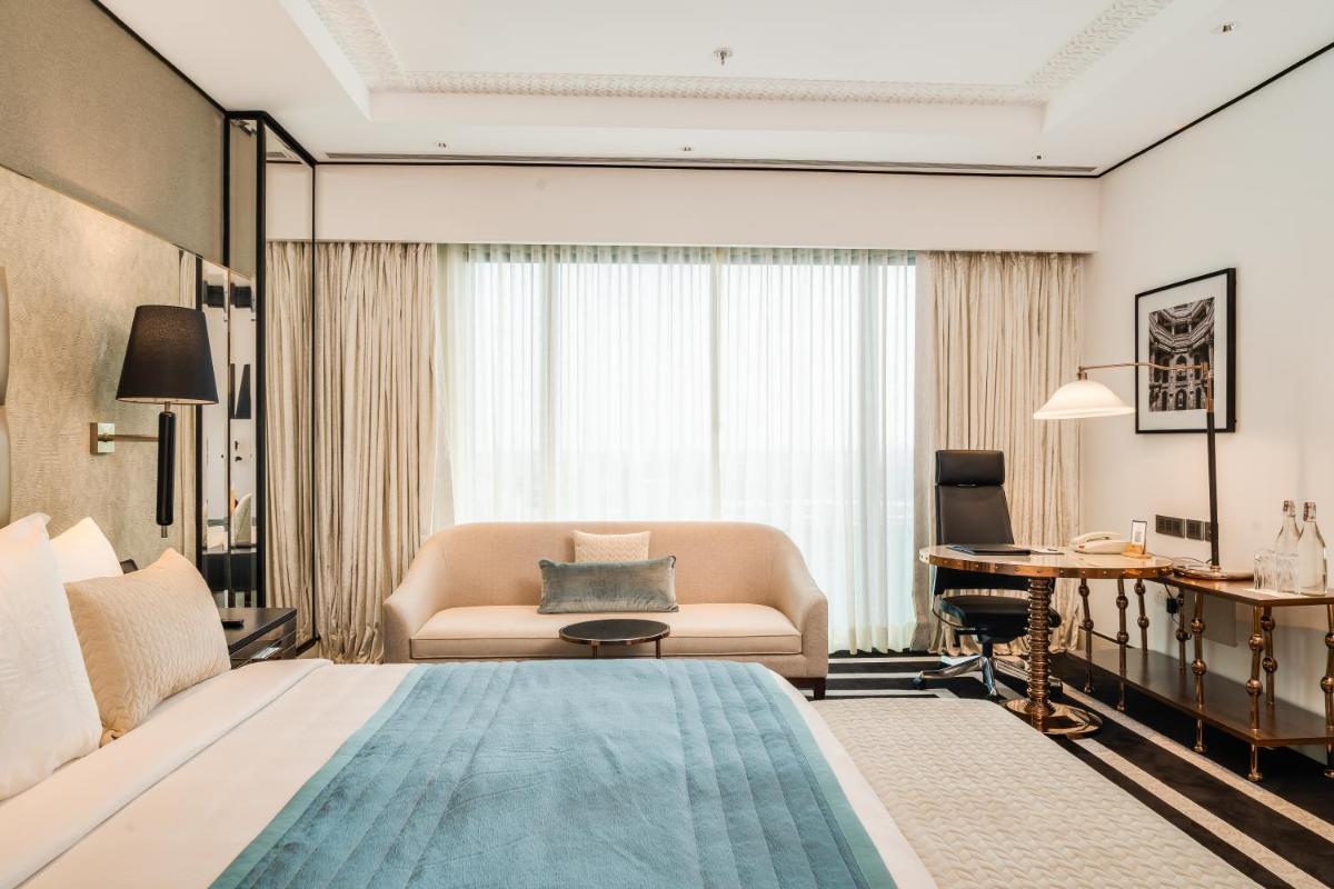 a hotel room with a large bed and a couch at ITC Narmada, a Luxury Collection Hotel, Ahmedabad in Ahmedabad