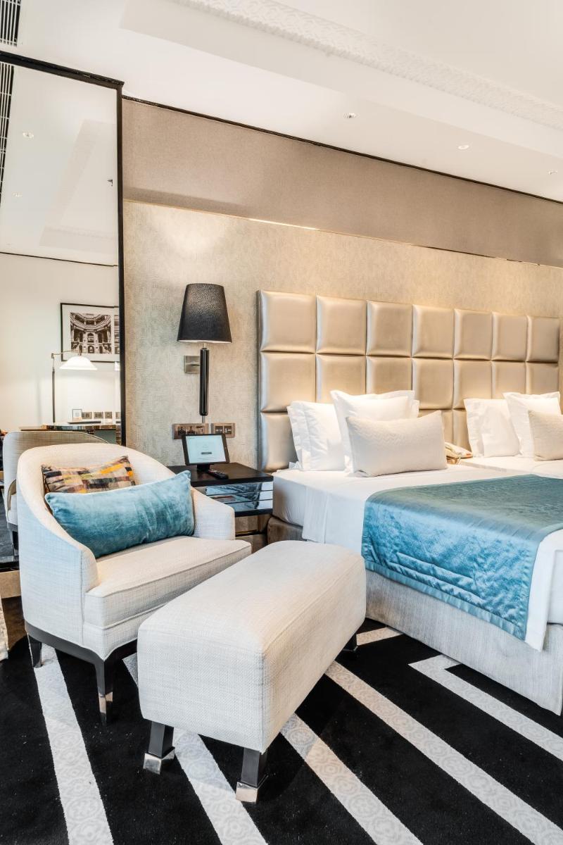 a hotel room with two beds and a chair at ITC Narmada, a Luxury Collection Hotel, Ahmedabad in Ahmedabad