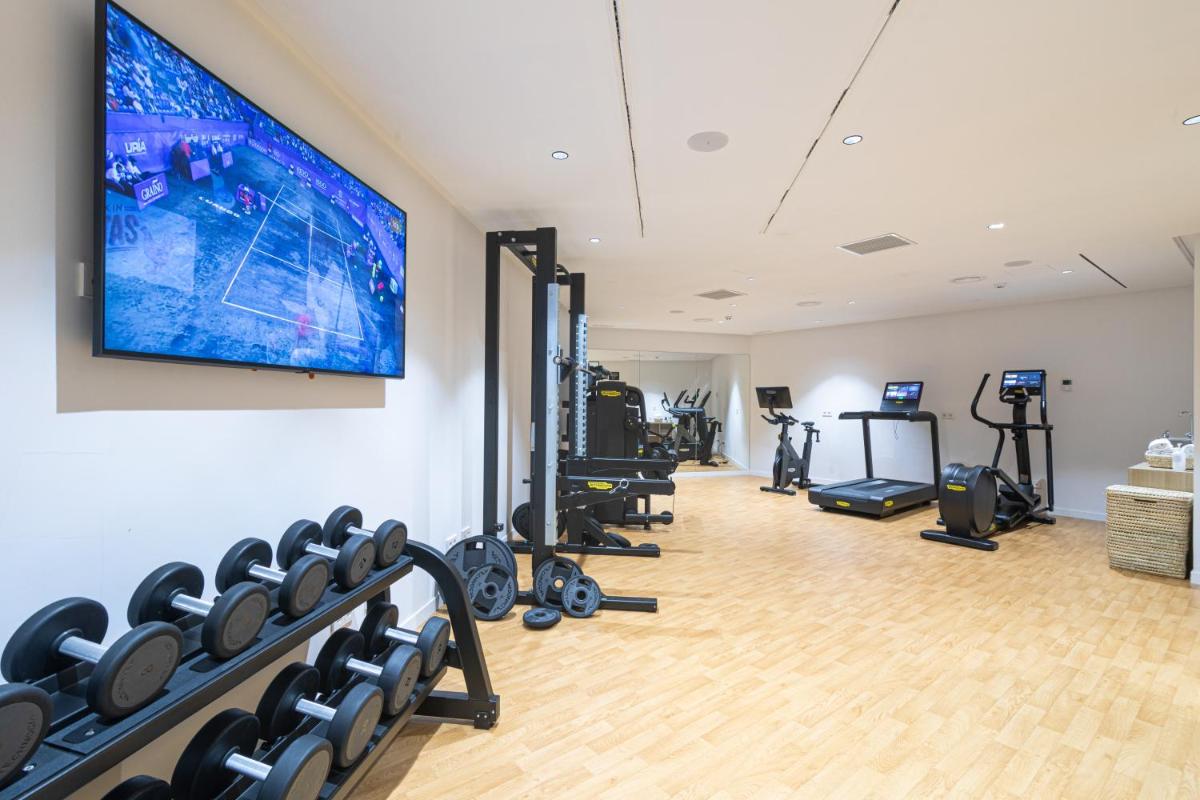 un gimnasio con máquinas de correr y TV de pantalla plana en JS Palma Plaza, en Palma de Mallorca