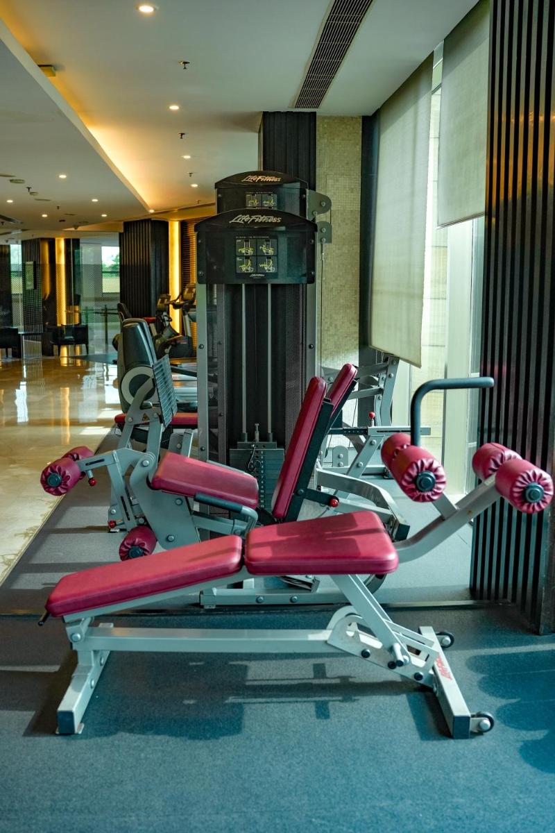 a gym with red cardio equipment in a building at Courtyard by Marriott Gurugram Downtown in Gurgaon