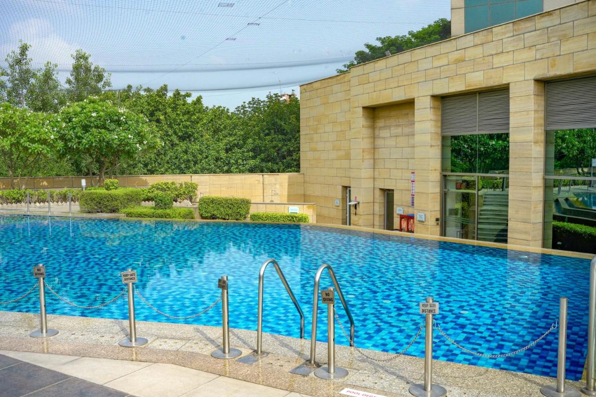 a large blue swimming pool in front of a building at Courtyard by Marriott Gurugram Downtown in Gurgaon