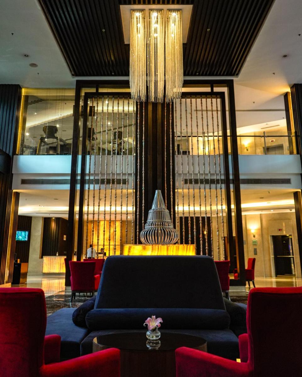 a lobby with a blue couch and a chandelier at Courtyard by Marriott Gurugram Downtown in Gurgaon