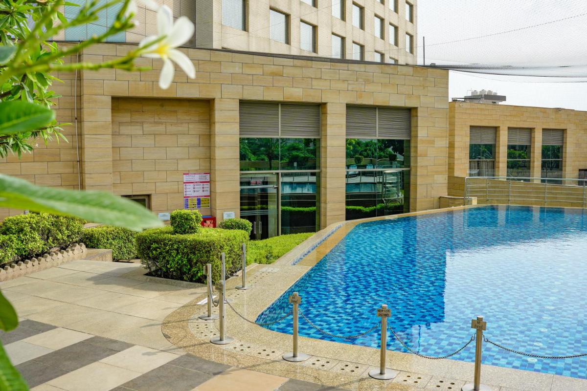 a swimming pool in front of a building at Courtyard by Marriott Gurugram Downtown in Gurgaon