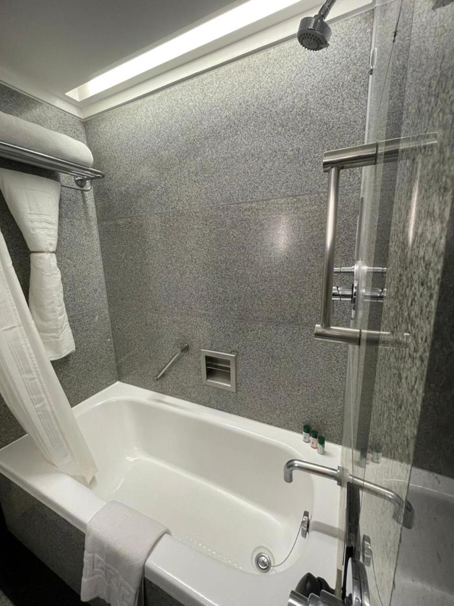 a white bath tub in a bathroom with a shower at Hotel Marine Plaza in Mumbai
