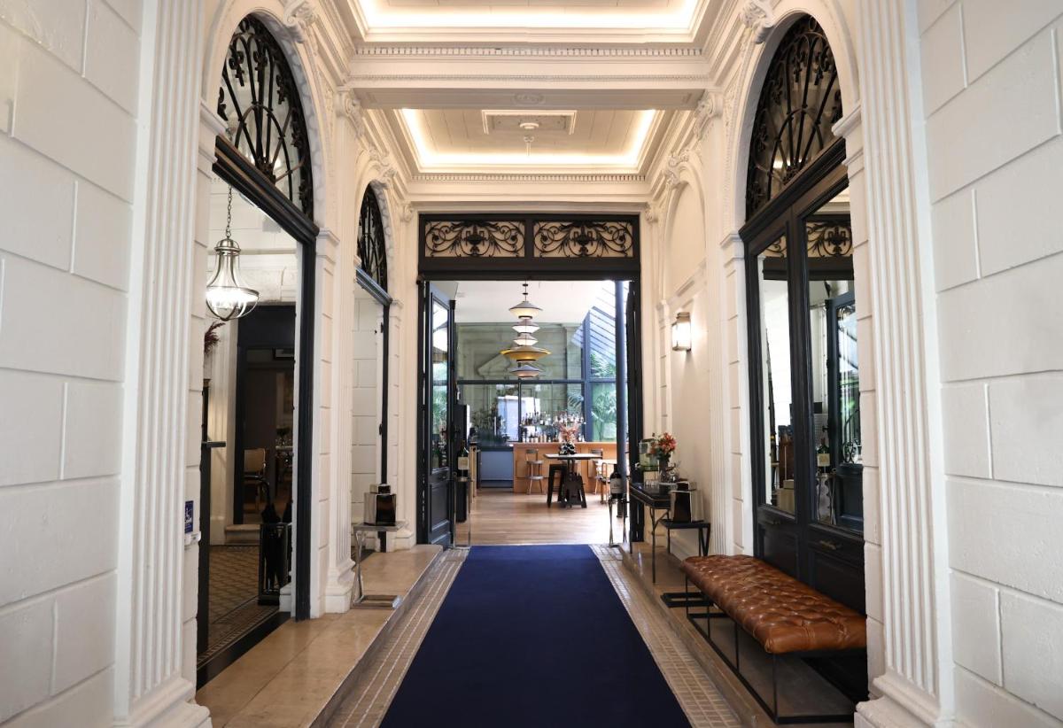 - un couloir avec un tapis bleu dans un bâtiment dans l'établissement Le Boutique Hotel & Spa, à Bordeaux