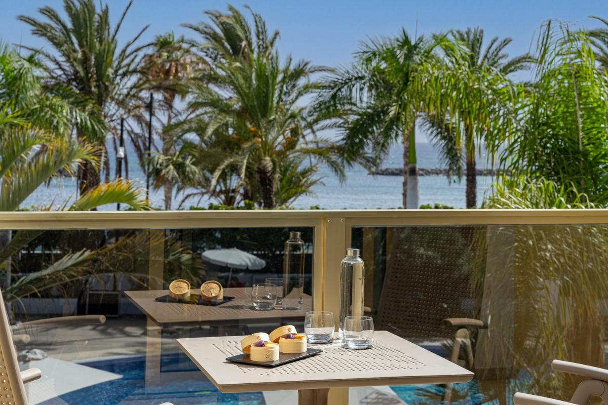 Un balcón con mesas y vistas al océano. en Sir Anthony, en Playa de las Américas