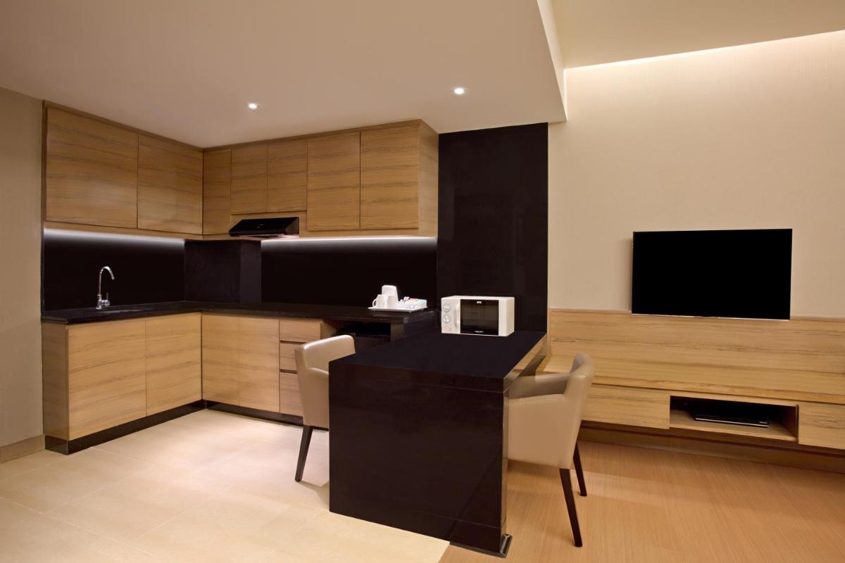 a kitchen with a table and chairs and a television at DoubleTree Suites by Hilton Bengaluru Outer Ring Road in Bengaluru
