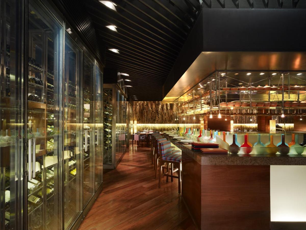 a restaurant with a bar with a bunch of vases at President - IHCL SeleQtions in Mumbai