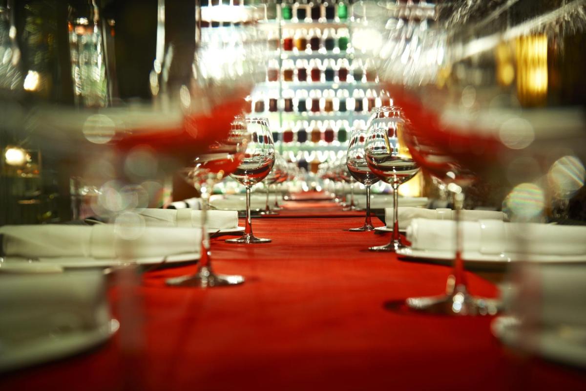 a row of wine glasses sitting on a table at President - IHCL SeleQtions in Mumbai