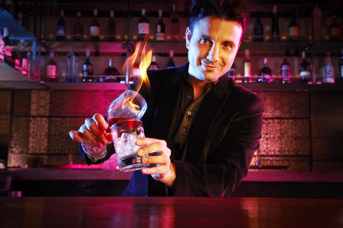 a man holding a wine glass in a bar at President - IHCL SeleQtions in Mumbai