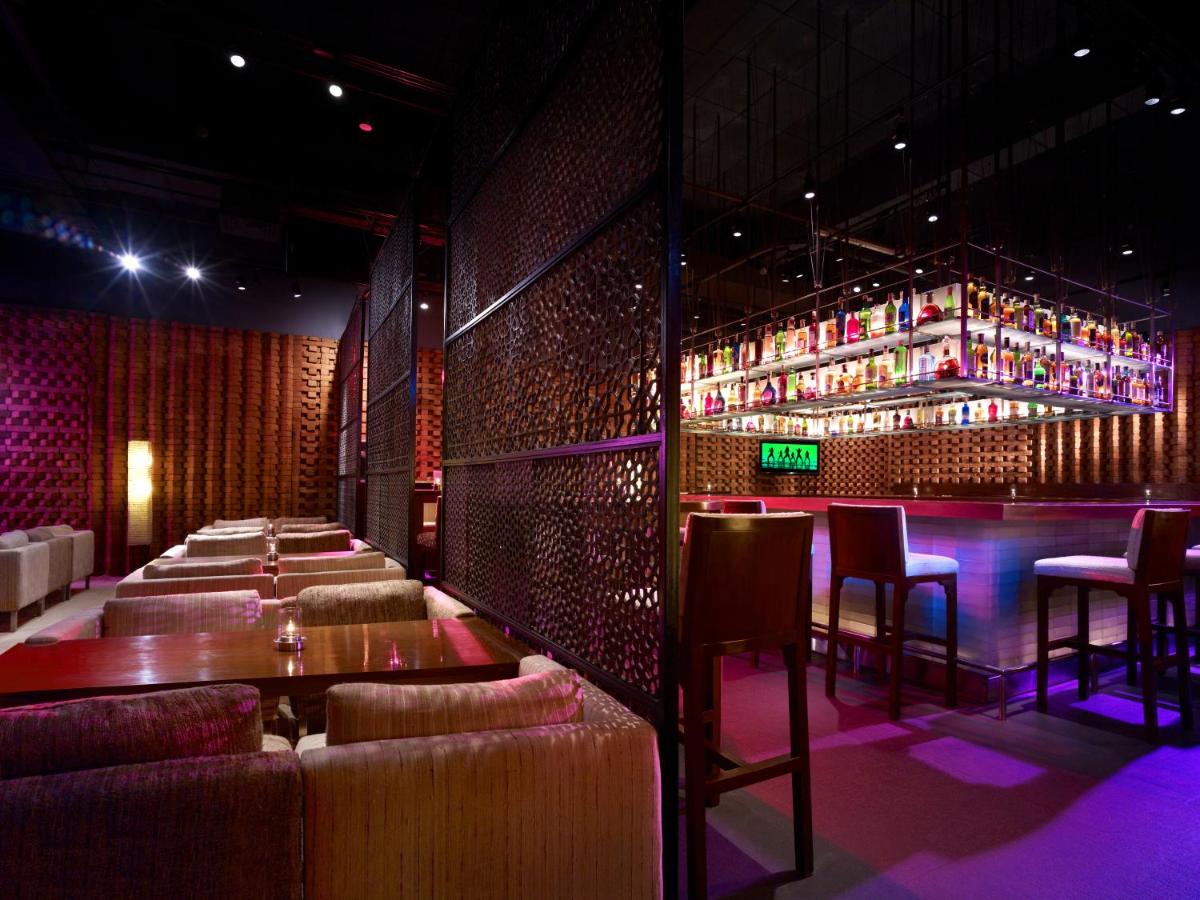 a bar with couches and a table in a room at President - IHCL SeleQtions in Mumbai