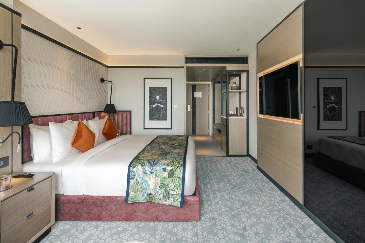 a hotel room with a large bed and a television at Parallel Hotel Udaipur, a member of Radisson Individuals in Udaipur