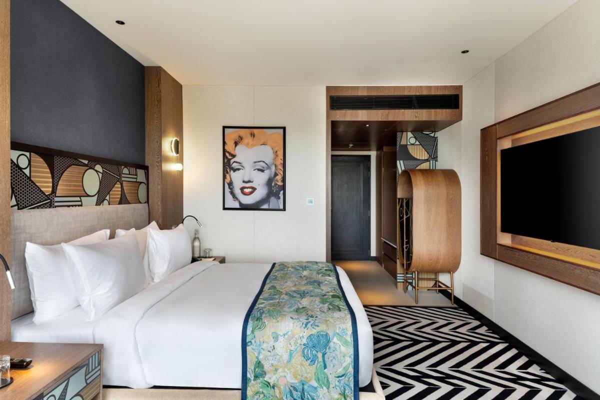 a hotel room with a large bed and a flat screen tv at Parallel Hotel Udaipur, a member of Radisson Individuals in Udaipur